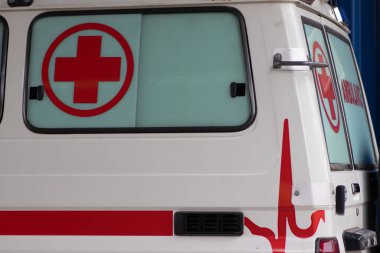 Acil tıbbi yardım için ambulans aracını kapatın. Görünür kırmızı haç, acil durum ışıkları ve siren.
