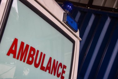 Acil tıbbi yardım için ambulans aracını kapatın. Görünür kırmızı haç, acil durum ışıkları ve siren.