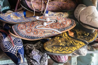 Geleneksel sokak pazarı veya Suk 'ta satılık, güzel dekoratif süslemeli el yapımı Arapça ayakkabılar.