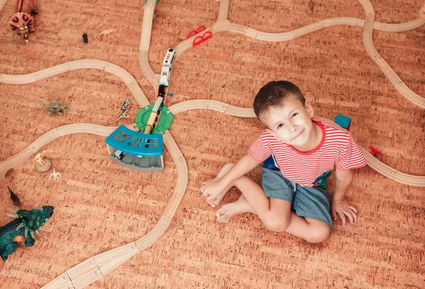 Παιδί παίζει με ξύλινο σιδηροδρομικό δρόμο στο δωμάτιό του, τον τρόπο ζωής — Φωτογραφία Αρχείου