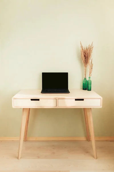 घर के इंटीरियर में टेबल पर काले लैपटॉप। स्टाइलिश कार्यस्थल — स्टॉक फ़ोटो, इमेज