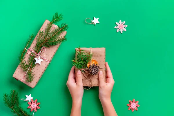 Manos de mujer con caja de regalo sobre fondo verde —  Fotos de Stock