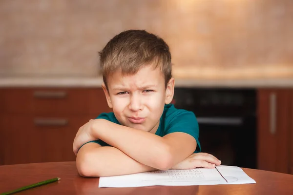 7 yeas vecchio ragazzo seduto a tavola e piangendo mentre si lavora sul duro lavoro — Foto Stock