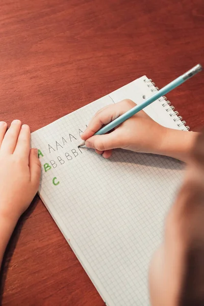 Tutup tampilan dari belakang ke anak untuk menulis surat di notebook — Stok Foto