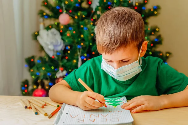 7 lat chłopiec napisać list do Mikołaja siedzi przy biurku — Zdjęcie stockowe