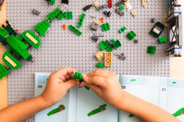 Talimatlara göre kondüktör Lego 'yu toplayan çocuğun elleri
