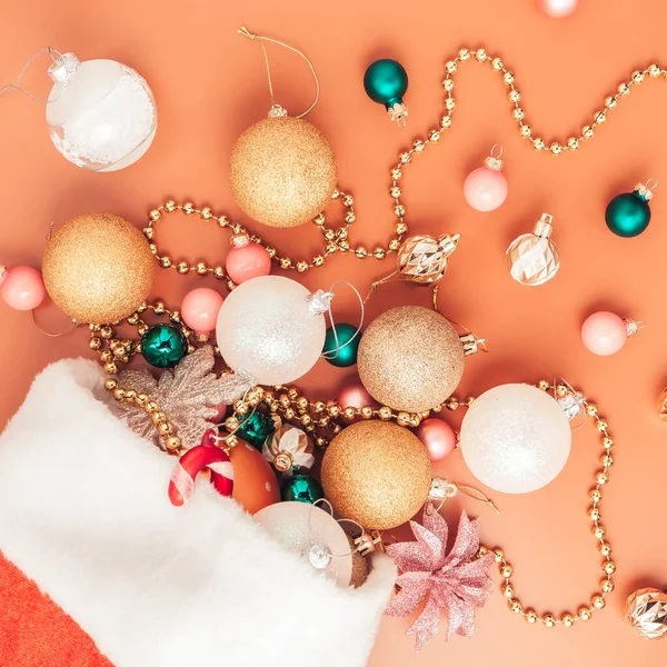 Decoraciones de Navidad caen del sombrero de santa sobre fondo naranja — Foto de Stock