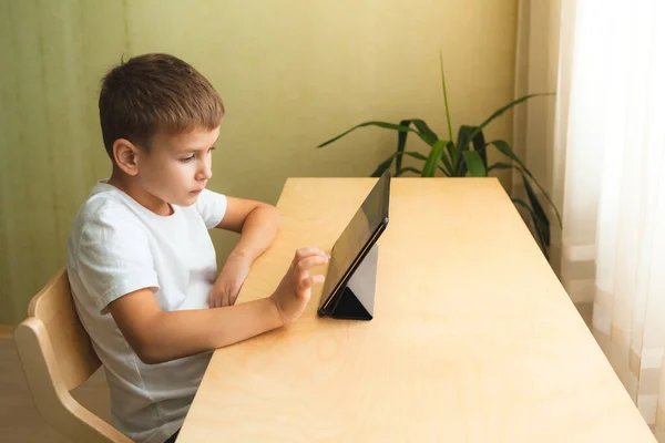 Anak manis melakukan pekerjaan rumah dengan laptop di rumah — Stok Foto