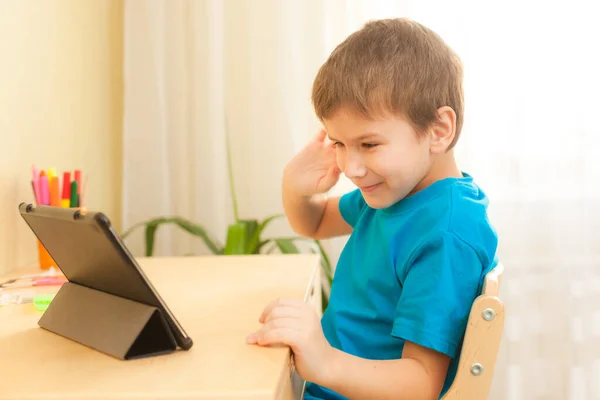7岁的男孩在网上用平板电脑授课 — 图库照片