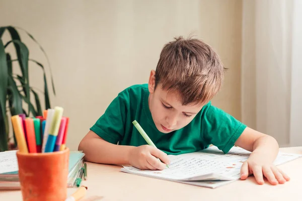 7 yaşında sevimli bir çocuk ödevini yapıyor. Masasında oturuyor. — Stok fotoğraf