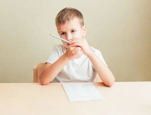 Mignon petit garçon apprendre à la maison. — Photo