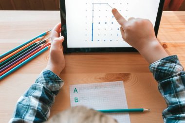 Modern çocuk evde çalışmak ve çizim yapmak için uygulamayı tablet üzerinde kullanır