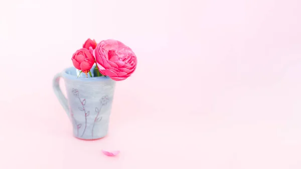 Schöner kleiner Strauß Rosen in Teetasse auf rosa Hintergrund — Stockfoto