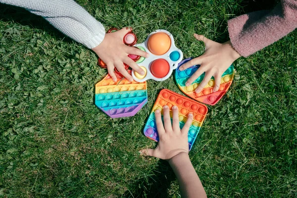 Kinderen trekken handen om het speelgoed pop — Stockfoto