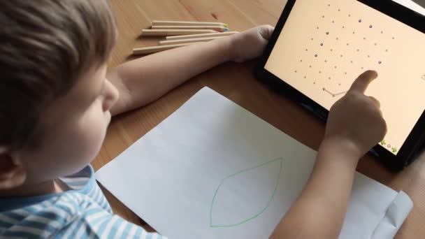 Enfant mignon utilise app sur tablette pour dessiner la lettre O — Video