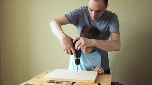 Otec a syn pracují společně, zatímco stojí na pracovním stole — Stock video