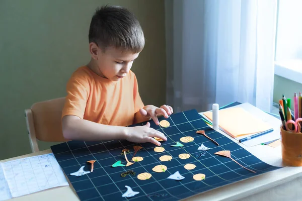子供は机でハロウィーンをテーマにボードゲームsittinfを作成 — ストック写真
