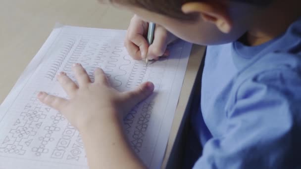 Garçon écriture sur feuille de calcul avec crayon — Video