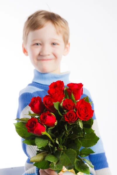 赤いバラの花束を持つ少年の笑顔 — ストック写真