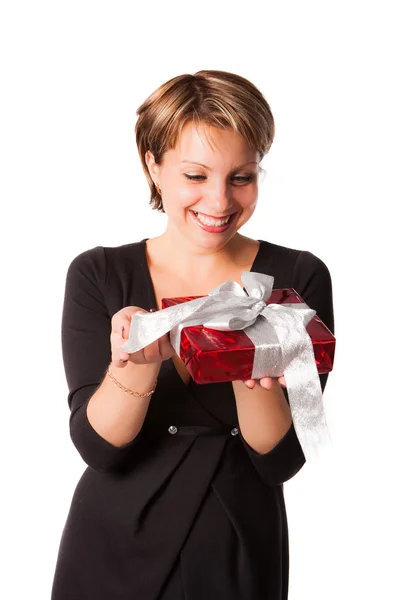 Happy woman in black dress looking at red gift box Stock Image