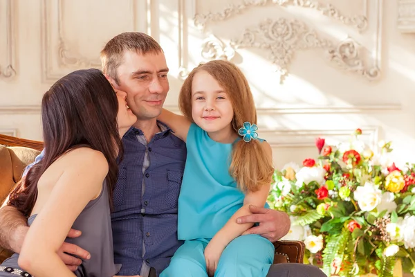 Sorrindo menina sentada com seu pai e mãe — Fotografia de Stock
