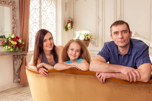Mãe, pai e filha sentados no sofá — Fotografia de Stock