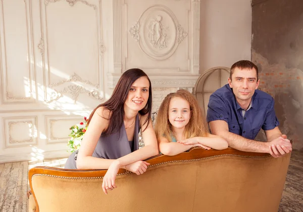 A family of three sitting on couch — Stock fotografie