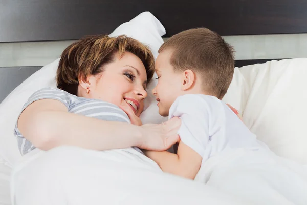 Kleiner Junge mit seiner Mutter im Bett — Stockfoto