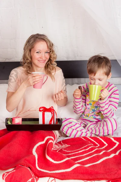 Smiling woman with her child having breakfast — ストック写真