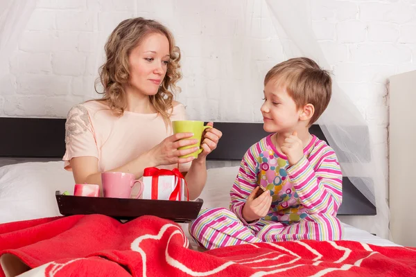 Beautiful woman with her son having breakfast — 图库照片