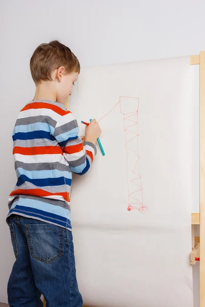 Little child drawing picture on easel — ストック写真