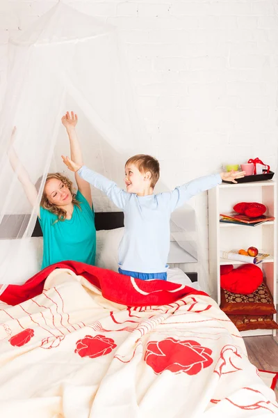 Mother and son waking up in bed — Stock Photo, Image