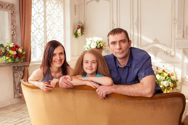 Родители и дочь сидят на диване — стоковое фото