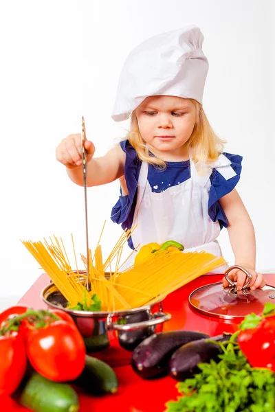 Ωραίο κοριτσάκι στο καπάκι το μαγείρεμα των ζυμαρικών — Φωτογραφία Αρχείου