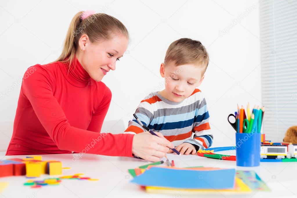 Preschooler child drawing with his mom 