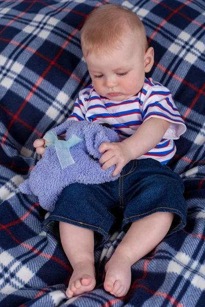 Kleiner Junge sitzt auf weichem Teppich — Stockfoto