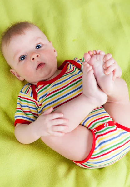 Cute boy holding his feet — Stock Photo, Image