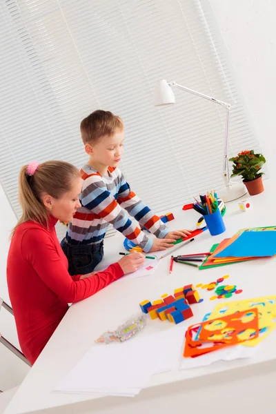 Mãe e seu filho na mesa branca — Fotografia de Stock