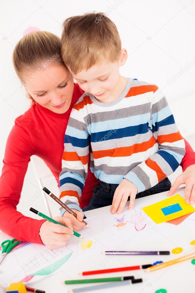 Mother teaching her little boy to draw
