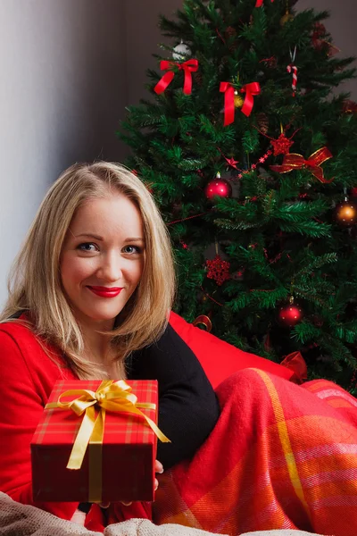 Beautiful woman gives red gift box — Stock Photo, Image