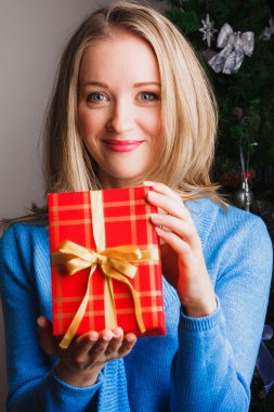 Kırmızı hediye tutan güzel sarışın kadın
