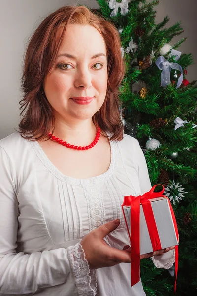 Frau steht mit Geschenk — Stockfoto