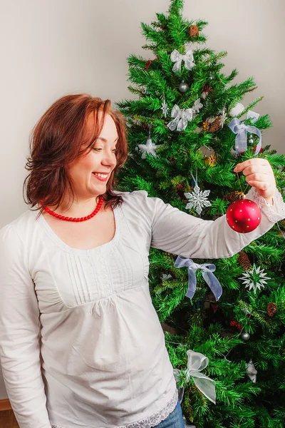 Счастливая женщина смотрит на рождественский мяч Стоковое Изображение