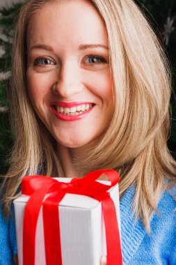 Gülümseyen kadın beyaz hediye kutusu tutar