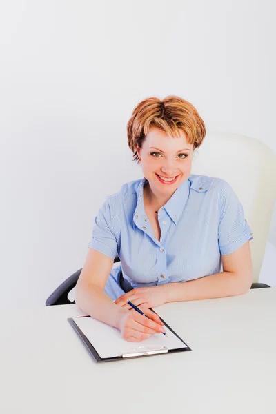 Lovely woman sitting by desk — Stock Photo, Image