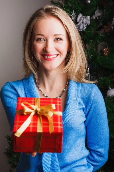 Laughing woman giving red gift — Stock Photo, Image