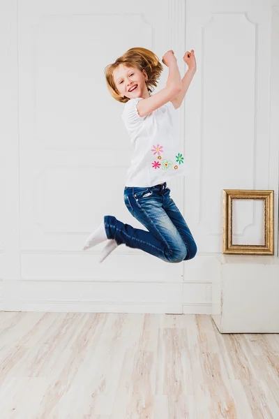 Menina feliz pulando na sala de luz — Fotografia de Stock