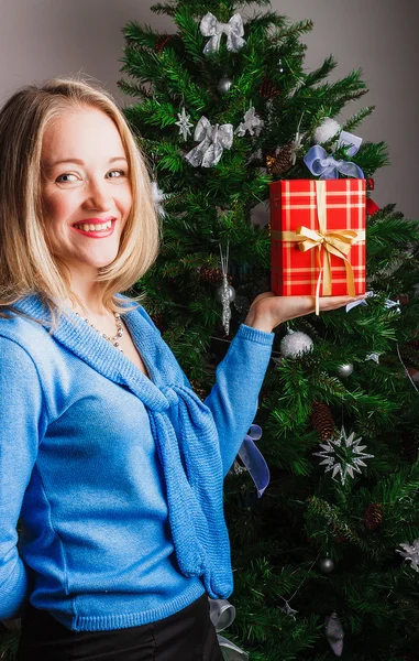 Mulher feliz de pé com presente — Fotografia de Stock