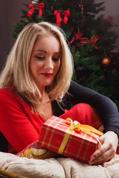 Mulher loira olha para caixa de presente vermelho — Fotografia de Stock