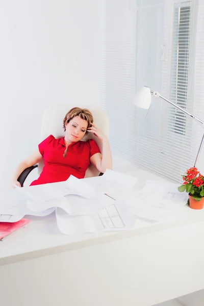 Woman sits by white desk and thinks — Stock Photo, Image